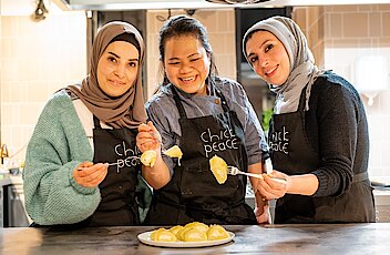 Foto: Drei Frauen präsentieren ein Essen